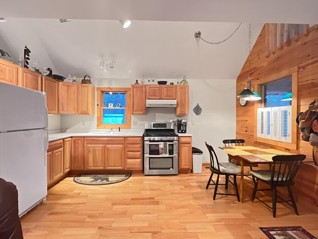 11 Crows Rd, Greenville, ME 04441 - kitchen with freestanding refrigerator, range with two ovens, under cabinet range hood, vaulted ceiling, and wooden walls