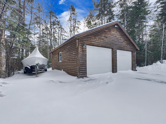 11 Crows Rd, Greenville, ME 04441 - snow covered property featuring faux log siding, an outdoor structure, and a detached garage