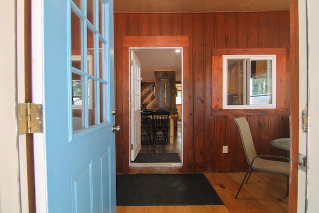 interior space with hardwood / wood-style floors and wooden walls