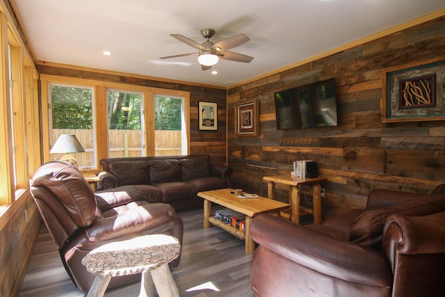 living room with dark hardwood / wood-style flooring, ceiling fan, and wood walls