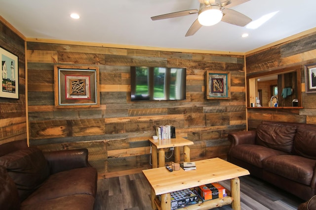 living room with wooden walls, ceiling fan, and dark hardwood / wood-style floors