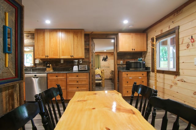 kitchen featuring appliances with stainless steel finishes, backsplash, and wooden walls