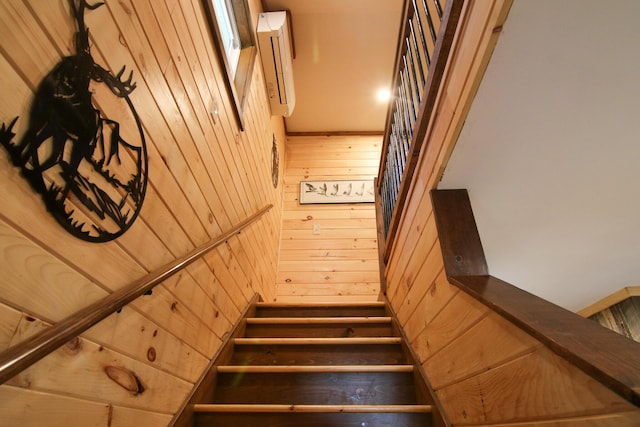 stairs featuring wooden walls and wood-type flooring