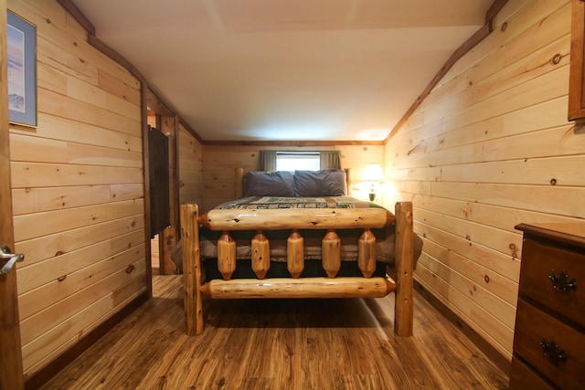 bedroom with dark hardwood / wood-style flooring, wooden walls, and vaulted ceiling