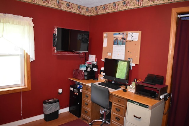 home office with light hardwood / wood-style flooring