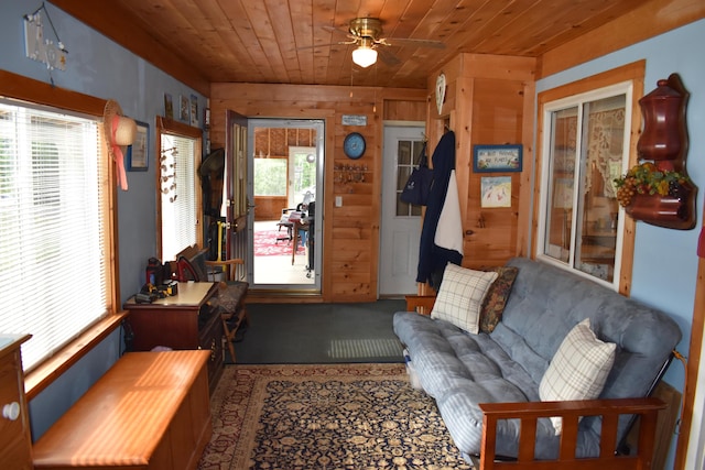 interior space featuring a wealth of natural light, ceiling fan, wood walls, and wood ceiling