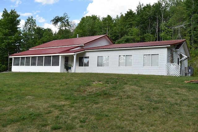 view of front of property featuring a front lawn and a sunroom