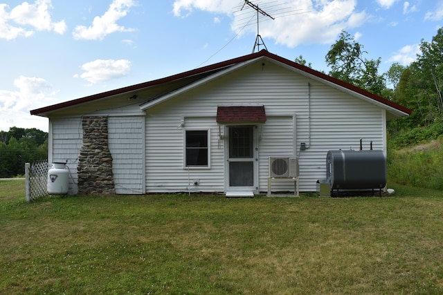 rear view of property featuring a yard and ac unit