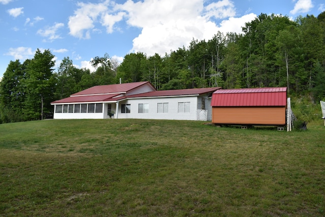 rear view of house with a sunroom and a yard