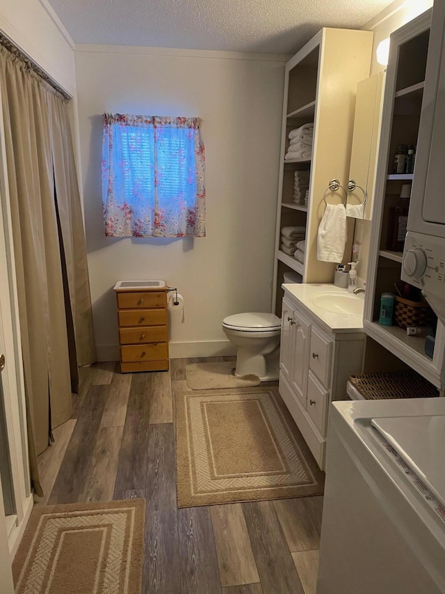 bathroom featuring vanity, wood-type flooring, a textured ceiling, and toilet