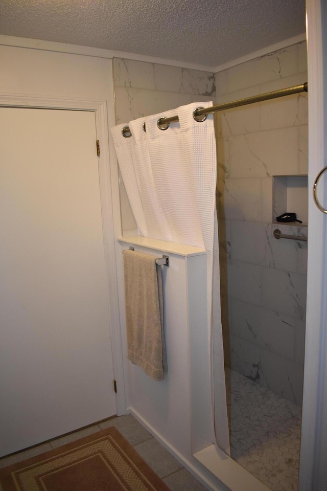 bathroom with a shower and a textured ceiling