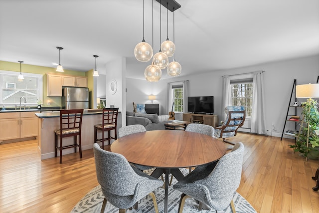 dining area featuring sink and light wood-type flooring