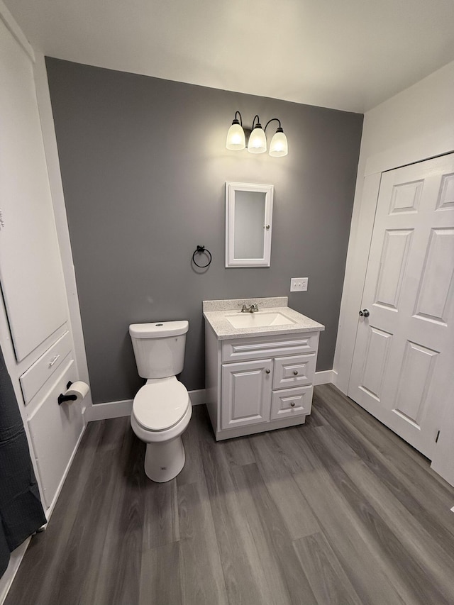 bathroom with toilet, wood-type flooring, and vanity