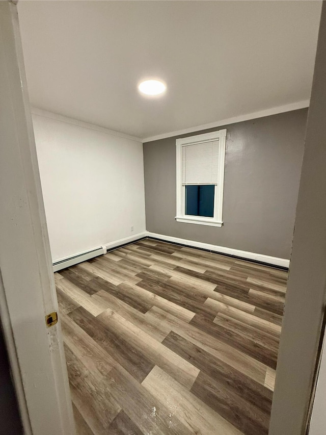 spare room featuring hardwood / wood-style floors and ornamental molding