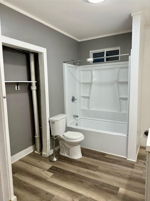 bathroom featuring shower / bathtub combination, crown molding, toilet, and wood-type flooring