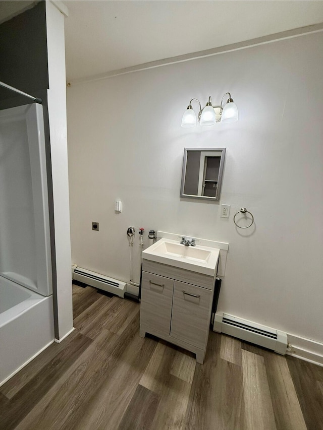 bathroom with bathing tub / shower combination, a baseboard radiator, vanity, and wood-type flooring