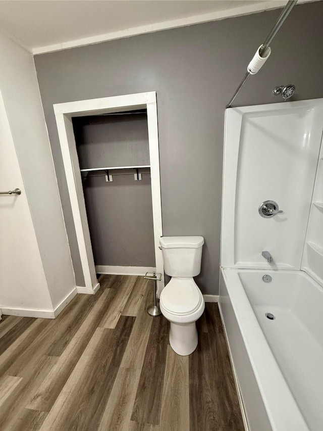 bathroom featuring  shower combination, toilet, and hardwood / wood-style flooring