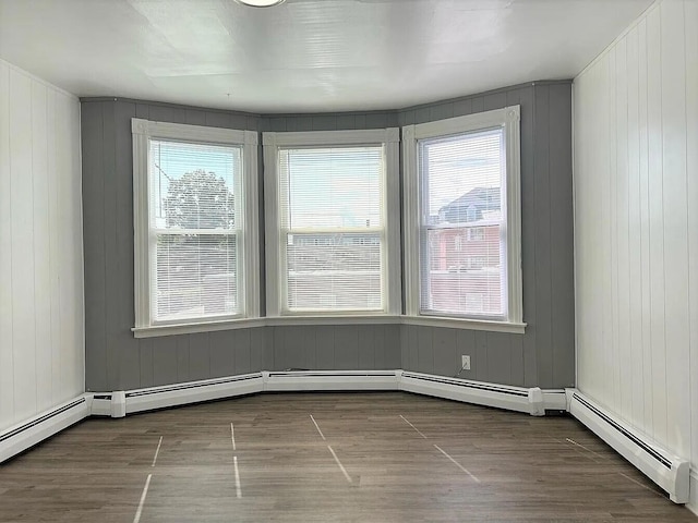 spare room featuring wooden walls and baseboard heating