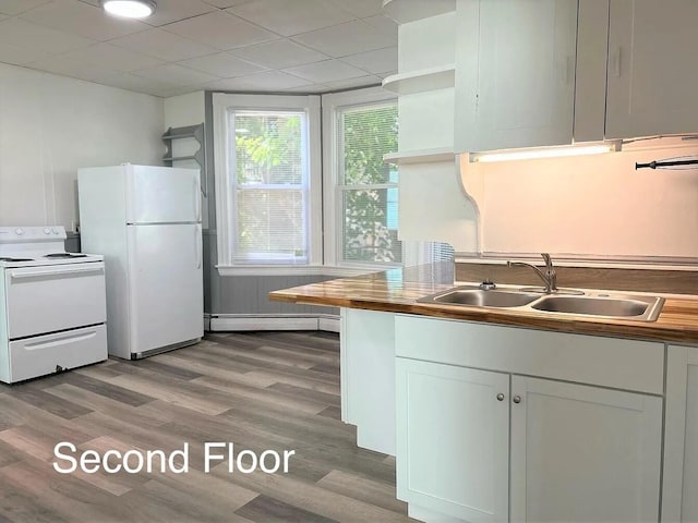 kitchen featuring sink, white cabinets, white appliances, wooden counters, and baseboard heating