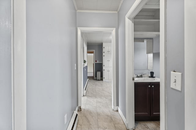 hallway with ornamental molding, sink, and a baseboard radiator