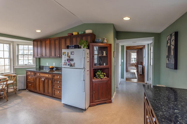 kitchen featuring radiator, plenty of natural light, lofted ceiling, and white refrigerator