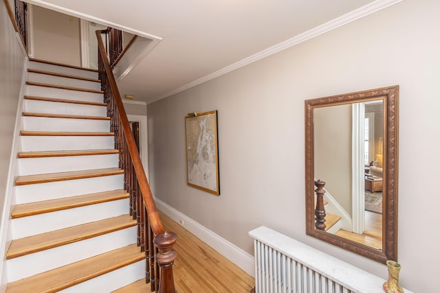 staircase with crown molding and hardwood / wood-style flooring