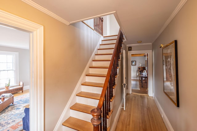 stairway featuring wood-type flooring and ornamental molding