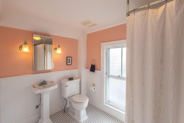 bathroom with crown molding, toilet, and walk in shower