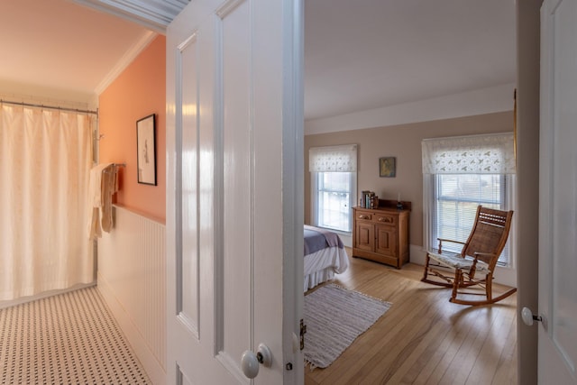 hall with light hardwood / wood-style flooring and ornamental molding