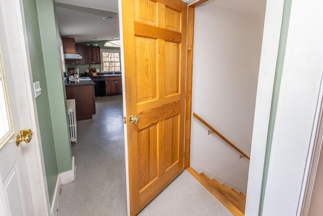 hall with radiator heating unit and vaulted ceiling