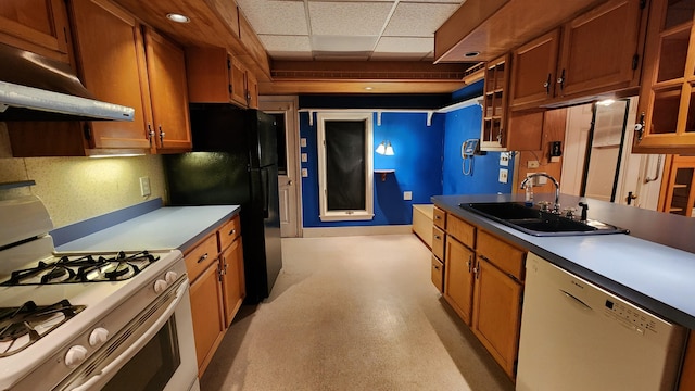 kitchen featuring white appliances, sink, and a drop ceiling