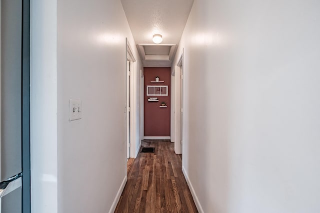 hall featuring a textured ceiling and dark hardwood / wood-style floors