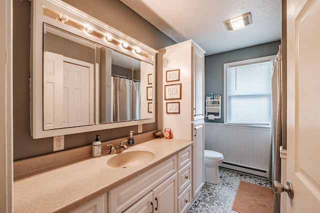 bathroom featuring vanity, a textured ceiling, a baseboard radiator, and toilet