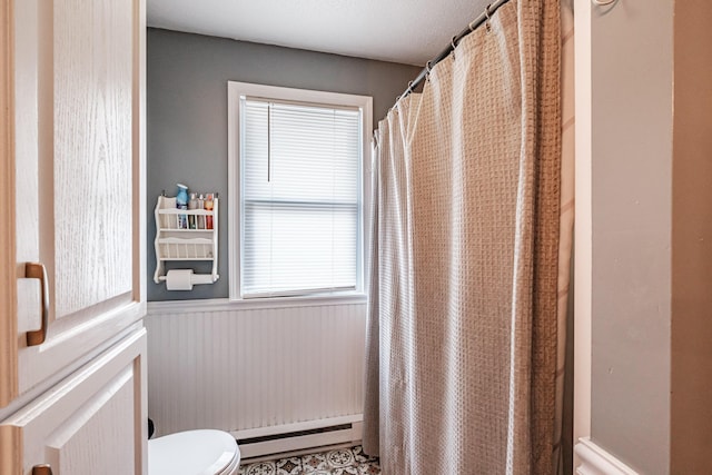 bathroom with tile patterned flooring, toilet, and a baseboard radiator