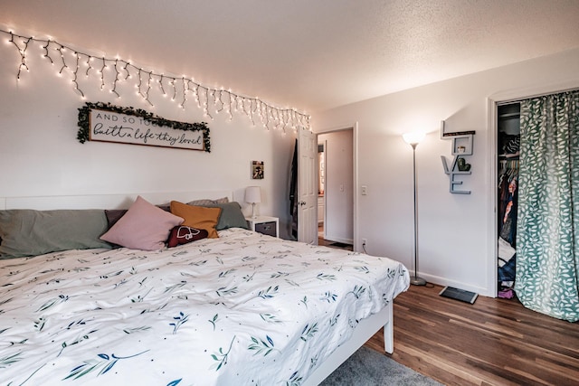 bedroom with wood-type flooring, a textured ceiling, and a closet