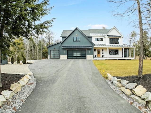 modern inspired farmhouse with a porch, a garage, and a front yard