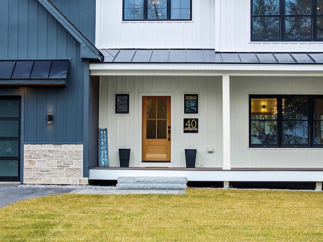 entrance to property with a lawn and a porch