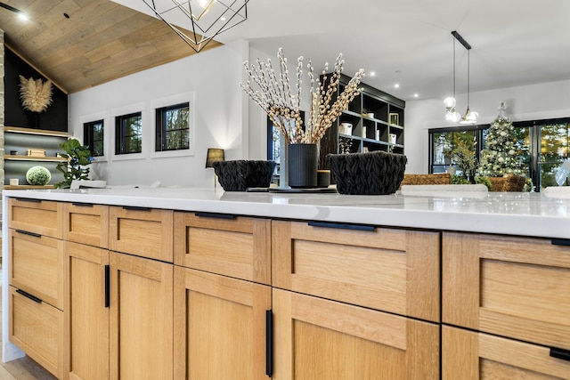 kitchen with light brown cabinetry, wood-type flooring, decorative light fixtures, an inviting chandelier, and wooden ceiling