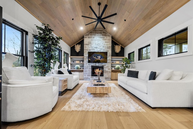 living room with plenty of natural light, light wood-type flooring, a fireplace, and wood ceiling