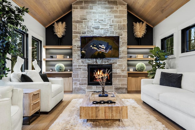 living room with wooden ceiling, light wood-type flooring, a fireplace, and vaulted ceiling