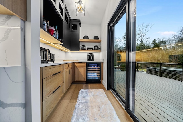 kitchen with light brown cabinetry, light hardwood / wood-style flooring, and wine cooler