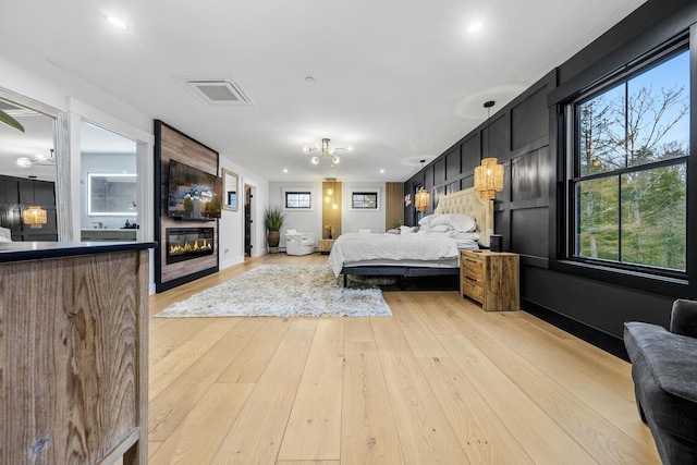 bedroom featuring a fireplace and light wood-type flooring