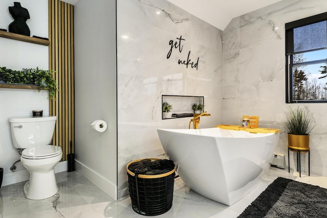 bathroom with a bathtub, toilet, and tile walls