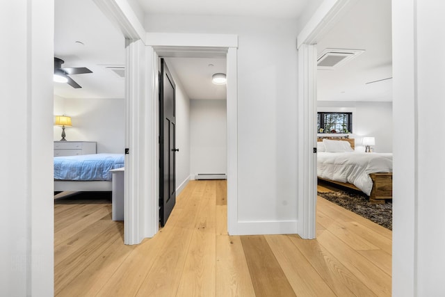 hallway featuring a baseboard radiator and hardwood / wood-style flooring