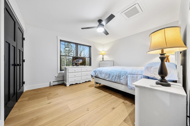 bedroom featuring ceiling fan, light hardwood / wood-style flooring, and a baseboard radiator