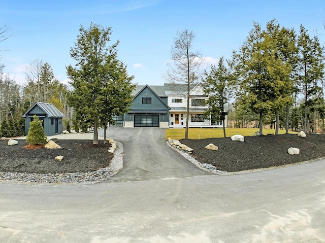 view of front of property with a storage unit, a garage, and a front yard