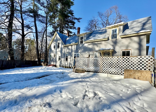 view of snow covered back of property