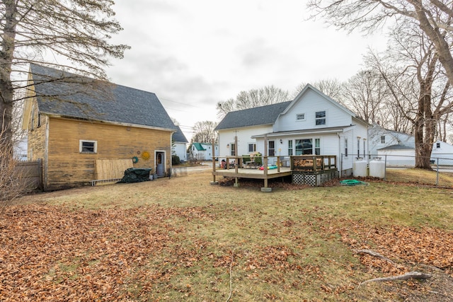 back of property featuring a lawn and a deck