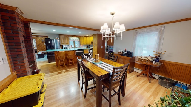 893 Horseback Rd, Levant, ME 04456 - dining area featuring light wood-type flooring, wooden walls, wainscoting, ornamental molding, and a chandelier