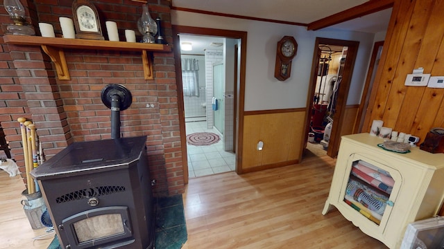 893 Horseback Rd, Levant, ME 04456 - living room featuring a wood stove, light wood-type flooring, wooden walls, wainscoting, and crown molding
